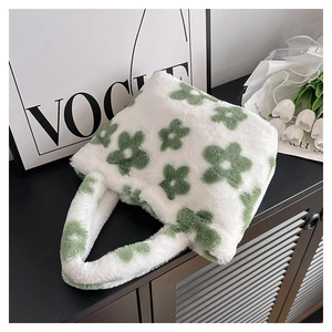 Detail of soft white faux fur tote bag with green floral patterns and wide plush handle