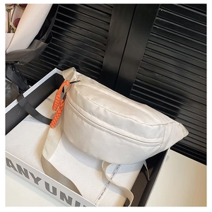 Detail of off-white crescent waist bag with orange paracord zipper pull for styling