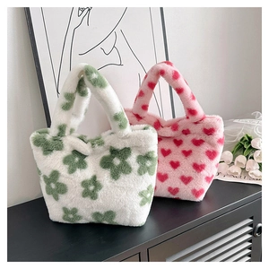 Close-up of fluffy floral and heart plush handbags set on a modern cabinet