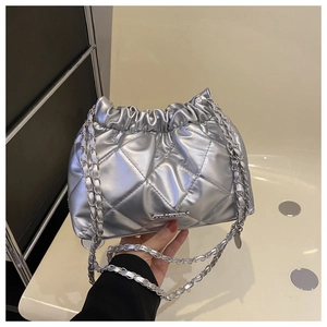 Dettaglio della borsa trapuntata argento con texture metallica e chiusura a coulisse