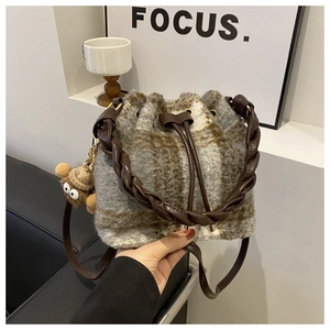 Plaid wool bucket bag with drawstring closure and plush charm in earthy tones