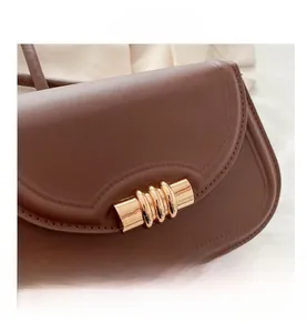 Dettaglio della borsa in pelle PU marrone scuro con fibbia a spirale in metallo dorato