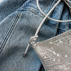 Detailaufnahme der silbernen Strass-Handtasche mit elegantem geflochtenem Metallgriff