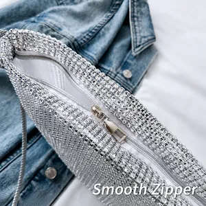 Detail der silbernen Strass-Tasche mit glattem Metallreißverschluss auf Jeans-Hintergrund