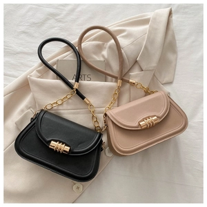 Dettagli di borse a tracolla in pelle minimaliste in nero e beige con catena dorata