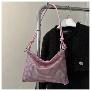 Détail d'un sac à bandoulière rose scintillant avec une élégante bandoulière nouée