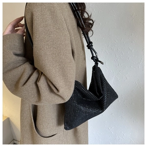 Détail d'un sac à bandoulière en sequins noirs étincelants avec poignée en cuir nouée