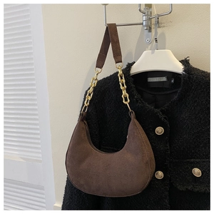 Detailed view of brown felt hobo bag with thick gold chain and zip closure