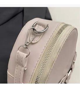 Vue macro détaillée du fermoir mousqueton argenté et de la fermeture éclair du mini sac rose