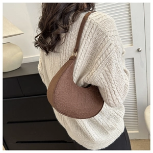 Dark brown faux crocodile texture crescent bag worn with a casual knit sweater
