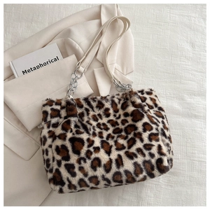 Detail of plush leopard print tote bag with white leather strap and silver chain links
