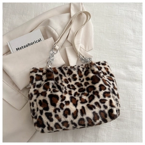 Detail of leopard print plush tote bag featuring cream leather strap and silver chain