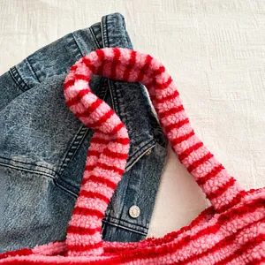 Details der weichen Plüschgriffe in Rosa und Rot gestreift an einer Winter-Handtasche
