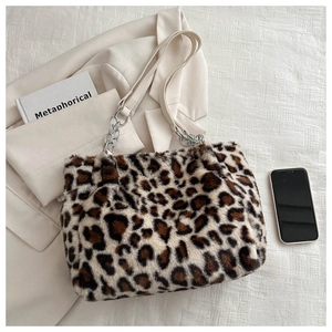 Detail of plush leopard print tote bag with silver chain strap and furry texture