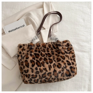 Detail of plush leopard print tote bag featuring faux leather strap and silver chain link