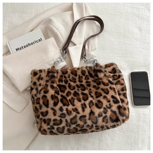Detail of leopard print plush tote bag featuring leather and silver chain strap