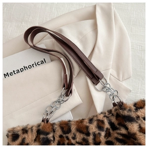 Macro view of leopard print faux fur texture and leather strap with silver chain links