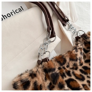 Detail of leopard print faux fur tote with brown leather strap and silver chain link