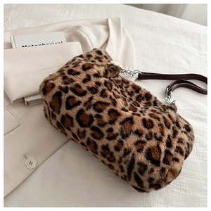 Detail of plush leopard print handbag with silver chain and brown leather strap
