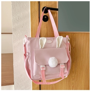Dettaglio della borsa in nylon rosa con graziose orecchie di coniglio e pompon