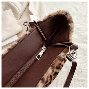 Close-up of leopard print faux fur bag with smooth silver zipper and metal ring details
