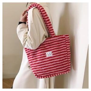Dettaglio della consistenza in peluche e della toppa con logo sulla borsa shopper a quadri