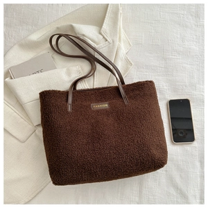 Détail du grand sac cabas en peluche marron avec écusson fashion et anse en cuir