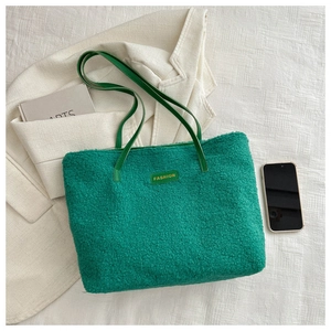 Détail du grand sac cabas en peluche verte avec étiquette de mode et texture douce