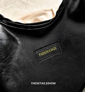 Close-up of black lychee texture leather shoulder bag with Fashion & Bags patch