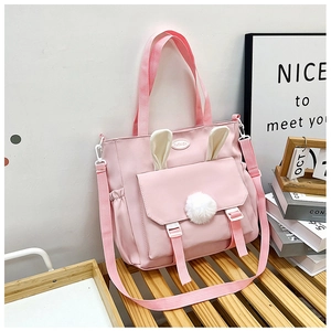 Dettaglio della borsa tote in nylon rosa con orecchie di coniglio 3D e pompon morbido