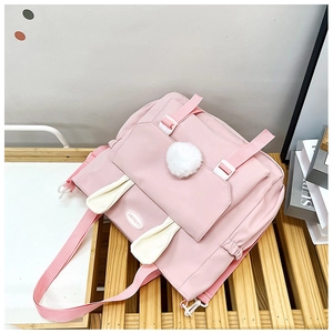 Dettaglio dello zaino in nylon rosa con graziose orecchie di coniglio e pompon bianco