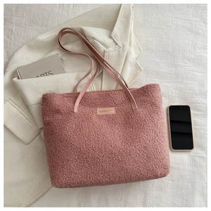 Vue à plat d'un sac cabas en fausse fourrure rose avec bandoulière en cuir