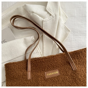 Gros plan sur le sac fourre-tout en faux mouton marron avec sangles en cuir et étiquette