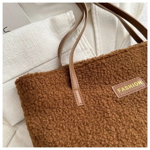 Gros plan du sac fourre-tout marron en peluche avec patch cuir FASHION et anse en cuir