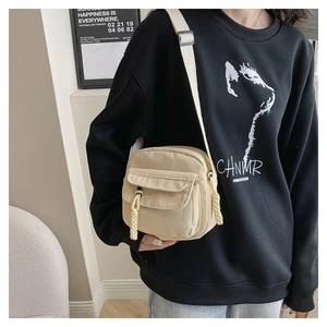 Detail van minimalistische beige corduroy crossbody tas met verstelbare riem en textuur