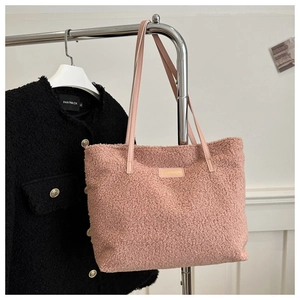 Detalle del bolso tote rosa de felpa con textura suave y etiqueta de moda frontal