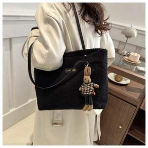 Détail du sac cabas noir en polaire avec étiquette FASHION et breloque lapin mignonne