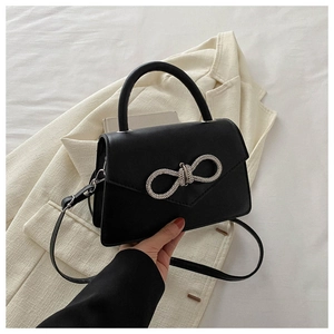 Elegant black leather handbag with rhinestone bow, crossbody strap and single handle