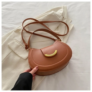 Detail of caramel brown semi-circle leather bag with elegant gold metal buckle hardware