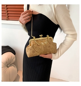 Détail du sac à chaîne vintage avec gaufrage floral, motifs de cerf et fermoir doré
