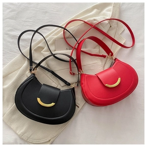Flat lay detail of black and red matte leather crossbody bags with golden hardware