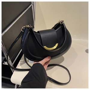 Detail of a black crescent moon handbag with matte leather and golden metal clasp
