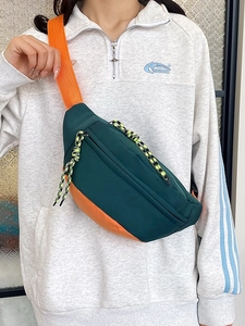 Green and orange contrast color nylon chest bag for men and women on gray sweatshirt