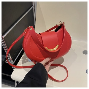 Detail of red crescent leather bag with golden metallic buckle and adjustable strap