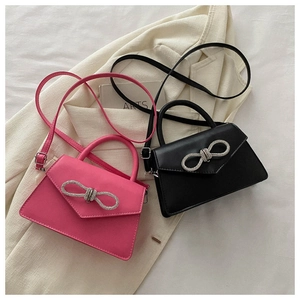 Detailed view of mini crossbody bags with rhinestone bow buckles in rose and black
