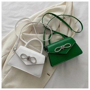 Detail of mini trapezoid handbags with crystal bow accents and smooth PU leather finish