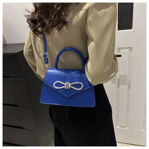 Klein blue faux leather crossbody bag with a sparkling rhinestone bow and top handle