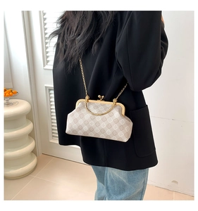 Detalle de bolso de cadena beige a cuadros con cierre dorado y asa superior redonda