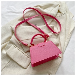 Detailansicht der pinken Kunstleder-Textur mit Nähten und goldenen Beschlägen der Tasche