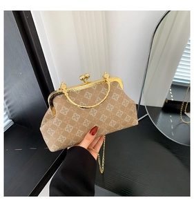 Primer plano detallado del bolso de concha retro con estampado de trébol y cierre dorado